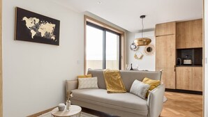A modern living room with a sofa, a round coffee table, and a world map on the wall.