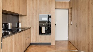 A modern kitchen with wooden cabinetry and a black countertop.