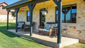 A covered outdoor seating area with wicker furniture and hanging planters.