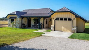 A two-story house with a stone exterior, a covered porch, and a garage.