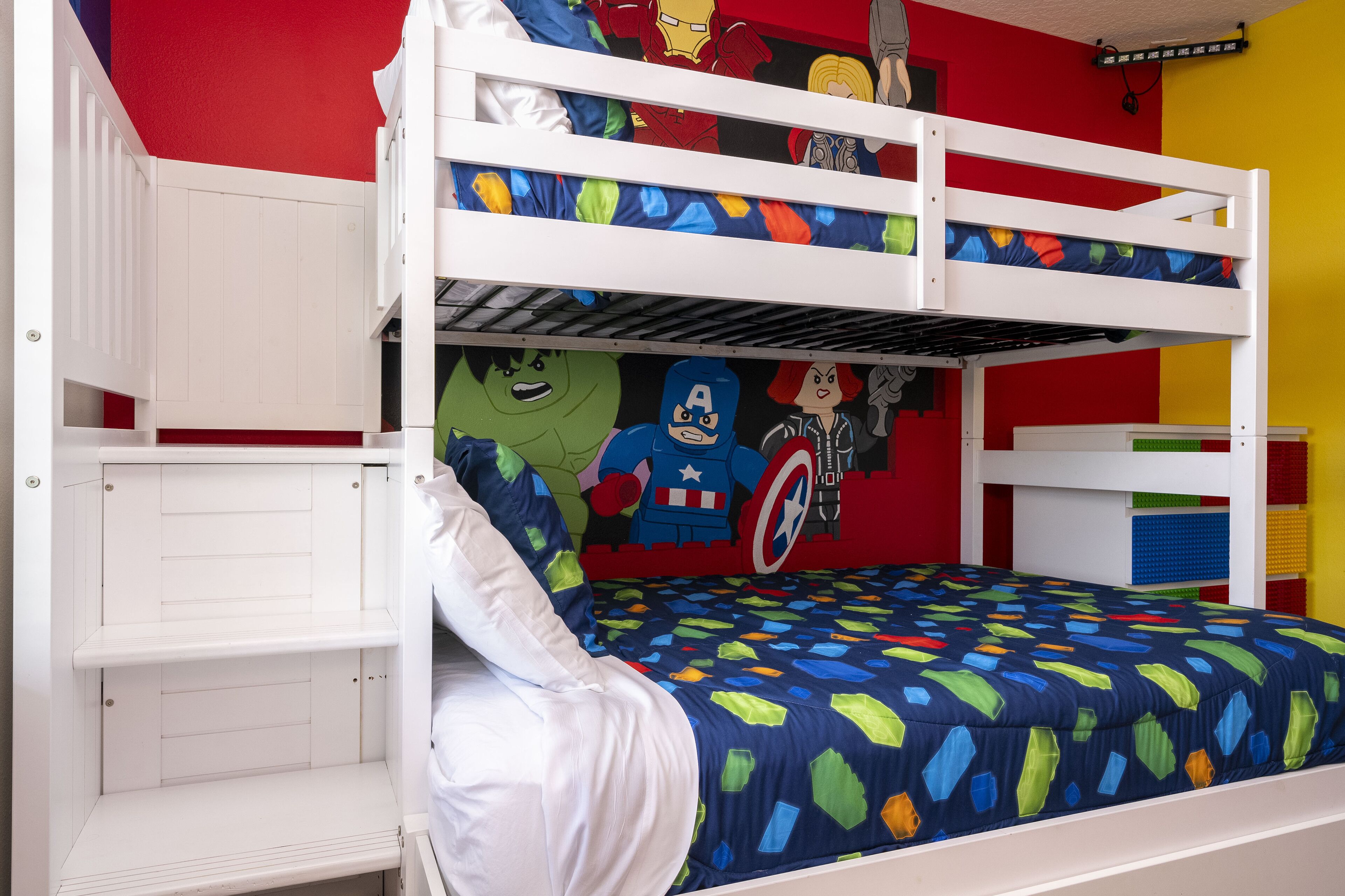 A bunk bed with superhero-themed bedding and wall decorations.
