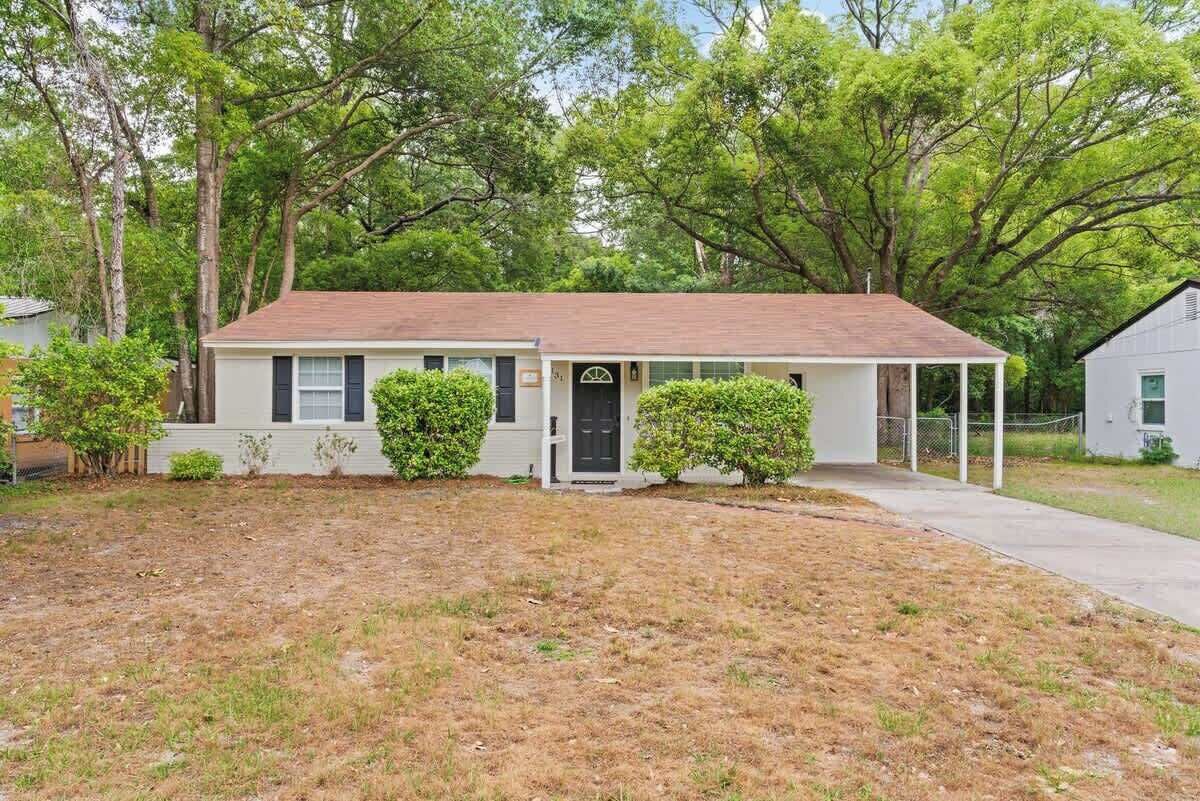 A single-story house with a front porch, a small front yard, and a garage.
