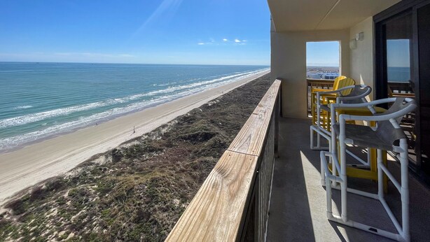 En balkon med udsigt over stranden og havet.