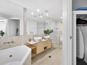 Een bad/douchecombinatie, een haardroger, handdoeken