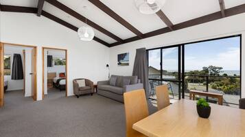 A spacious living area with a balcony, a dining table, and a sofa.
