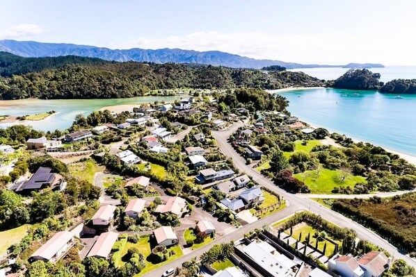 A coastal residential area with houses, roads, and a bay.