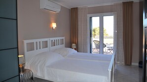 A hotel room with a double bed, a sliding glass door to a balcony, an air conditioning unit, and a lamp. - Casa Oslo - L'Estartit, Torre Vella (Estartit (L´))