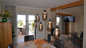 A dining area with a wooden table, black chairs, and hanging pendant lights. - Casa Oslo - L'Estartit, Torre Vella (Estartit (L´))