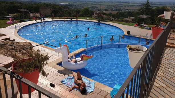 A swimming pool with a scenic view, a swan float, and a person sunbathing. - Casa Oslo - L'Estartit, Torre Vella (Estartit (L´))
