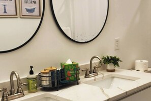 Une salle de bain avec deux lavabos, un miroir et divers produits de toilette.
