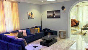 A modern living room with a sectional sofa, a coffee table, and a chandelier.
