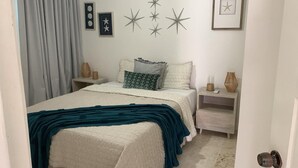 Une chambre à coucher avec un lit, des tables de chevet et une commode.