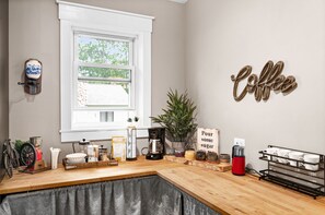 A kitchen counter with coffee-making equipment, a sign that says "Pour some sugar," and a coffee sign on the wall. - 6bd 3ba large gathering home, close to YMCA and 5 miles to Downtown Duluth (Hermantown)