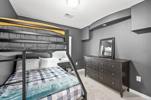 A bunk bed with a headboard, a dresser with drawers, and a mirror on the wall. - 6bd 3ba large gathering home, close to YMCA and 5 miles to Downtown Duluth (Hermantown)