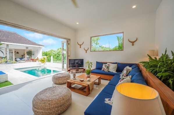 Relax in this spacious living room with a comfortable sofa, coffee table, and TV.