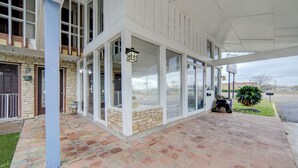 A building with a stone facade, large windows, and a covered patio area. - Cannon Inn By Capital O Gonzales Tx (Gonzales)