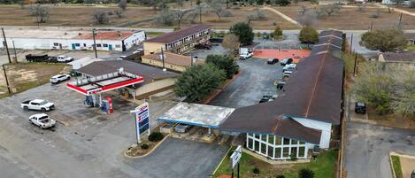 Vista aérea de una zona comercial que incluye una gasolinera, un motel y algunos edificios.