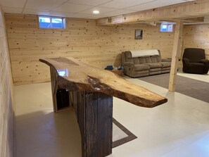 A room with wooden walls, a large wooden table, a sofa, and a chair.
