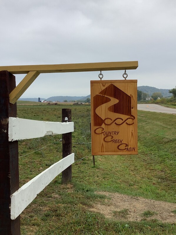 A wooden sign with the text "Country Creek Cabin" and a stylized mountain design.