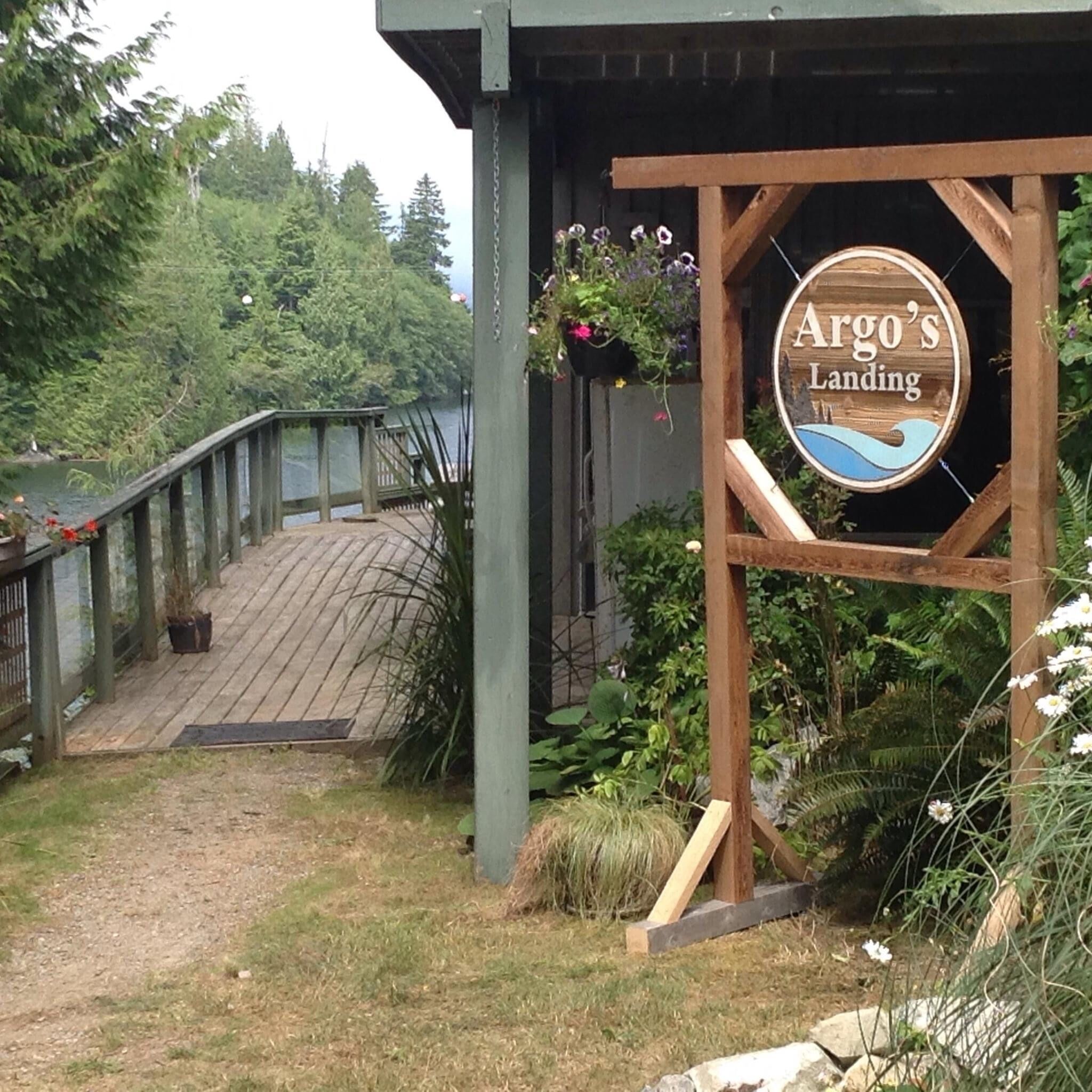 A wooden structure with a sign that reads "Argo's Landing" and a wooden deck leading to a dock.