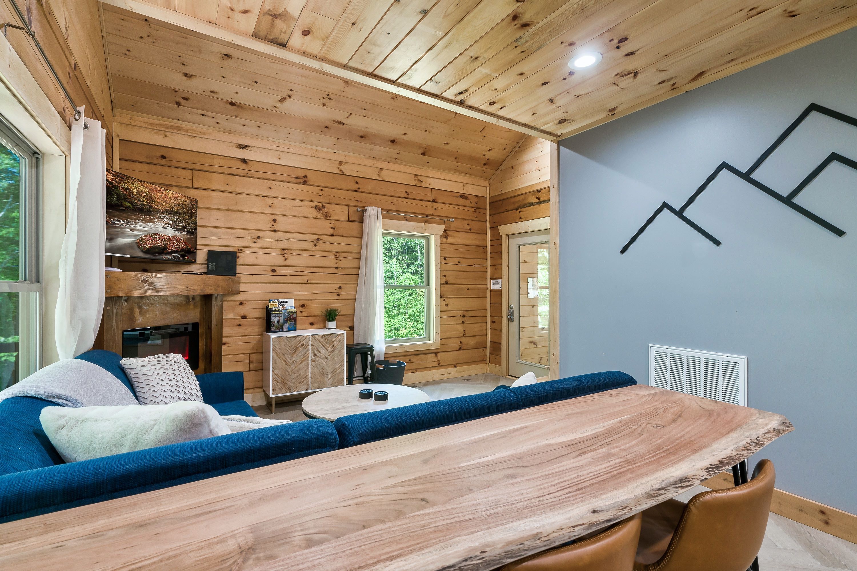 Un intérieur en bois avec une table à manger, un canapé et une cheminée.