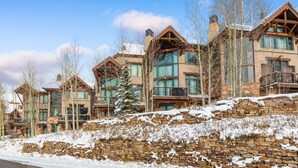 A row of modern, multi-story buildings with large windows and stone foundations, likely part of a resort or hotel complex. - Ski-in/ski-out with private hot tub! Sleeps 12 (Telluride)