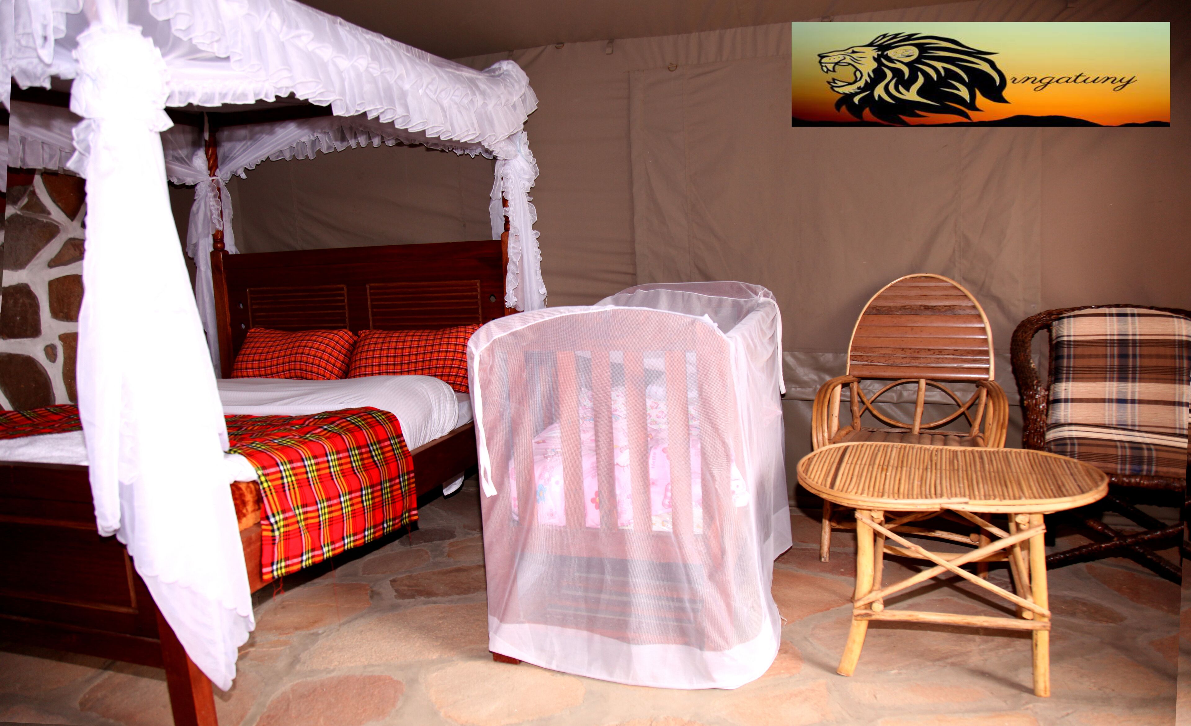 Quarto com cama de dossel, cortina, cadeira de vime e colcha xadrez.
