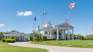 A large white building with a central dome and columns, surrounded by well-maintained lawns and multiple flags. - Golf Course Condo with Resort Style Pool, 5 Miles from Beach, Fully updated (Myrtle Beach)