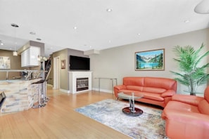 Relax in a stylish living space with a central seating area, fireplace, and kitchen bar.