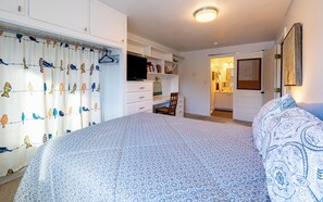 Ein Schlafzimmer mit Bett, Kleiderschrank, Schreibtisch und Stuhl.