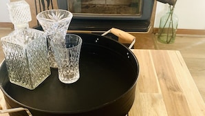 Une cuisine avec un fourneau, une poêle noire et de la verrerie en cristal sur une table en bois.