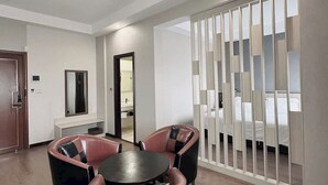 A modern hotel room with a round table, two chairs, a bed, and a sliding door with a view. - Dong Do Minh Nguyet (Vo Cuong)