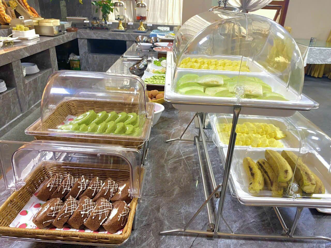 A buffet with various food items including bread, bananas, and green vegetables.