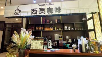 Interior de una cafetería con mostrador, máquinas de café y una pizarra con el menú.