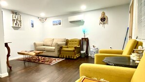 A living room with a sofa, armchairs, a coffee table, and a patterned rug. - Whisper Of Himalaya (Sylva)