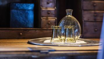 A wooden dresser with a glass bottle and three small glass vases on top.