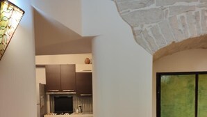 Un pasillo conduce a una cocina con electrodomésticos modernos, un comedor y vistas a un castillo a través de un ventanal.