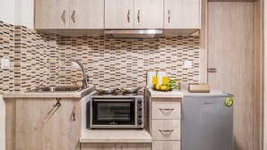 A compact kitchen with wooden cabinets, a built-in oven, a sink, and a small refrigerator. - Apartment 'Oceanida Aelia Room 2' with Shared Pool and Wi-Fi (Nikiana)