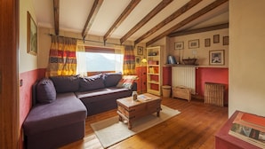 A cozy living room with a wooden ceiling, a sofa, a coffee table, and a bookshelf. - Casa del Picchio in Adrara San Martino (Adrara San Martino)
