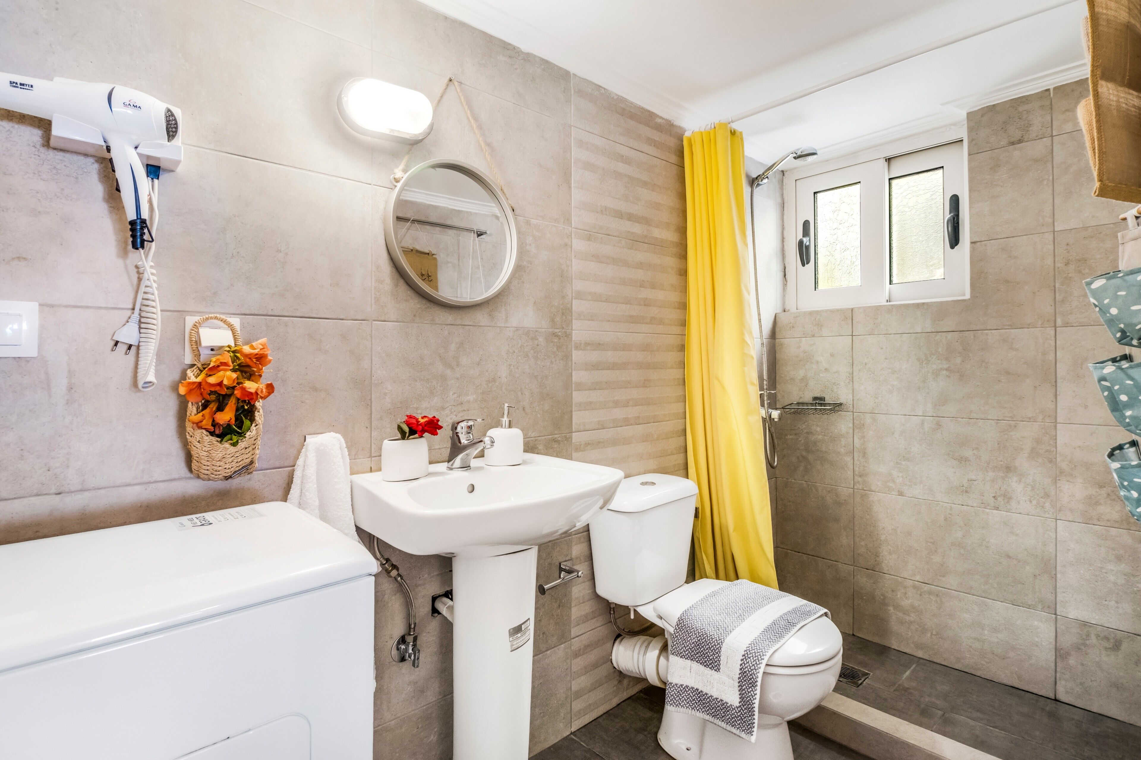 A bathroom with a white sink, toilet, and shower curtain.