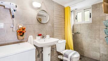 A bathroom with a white sink, toilet, and shower curtain.