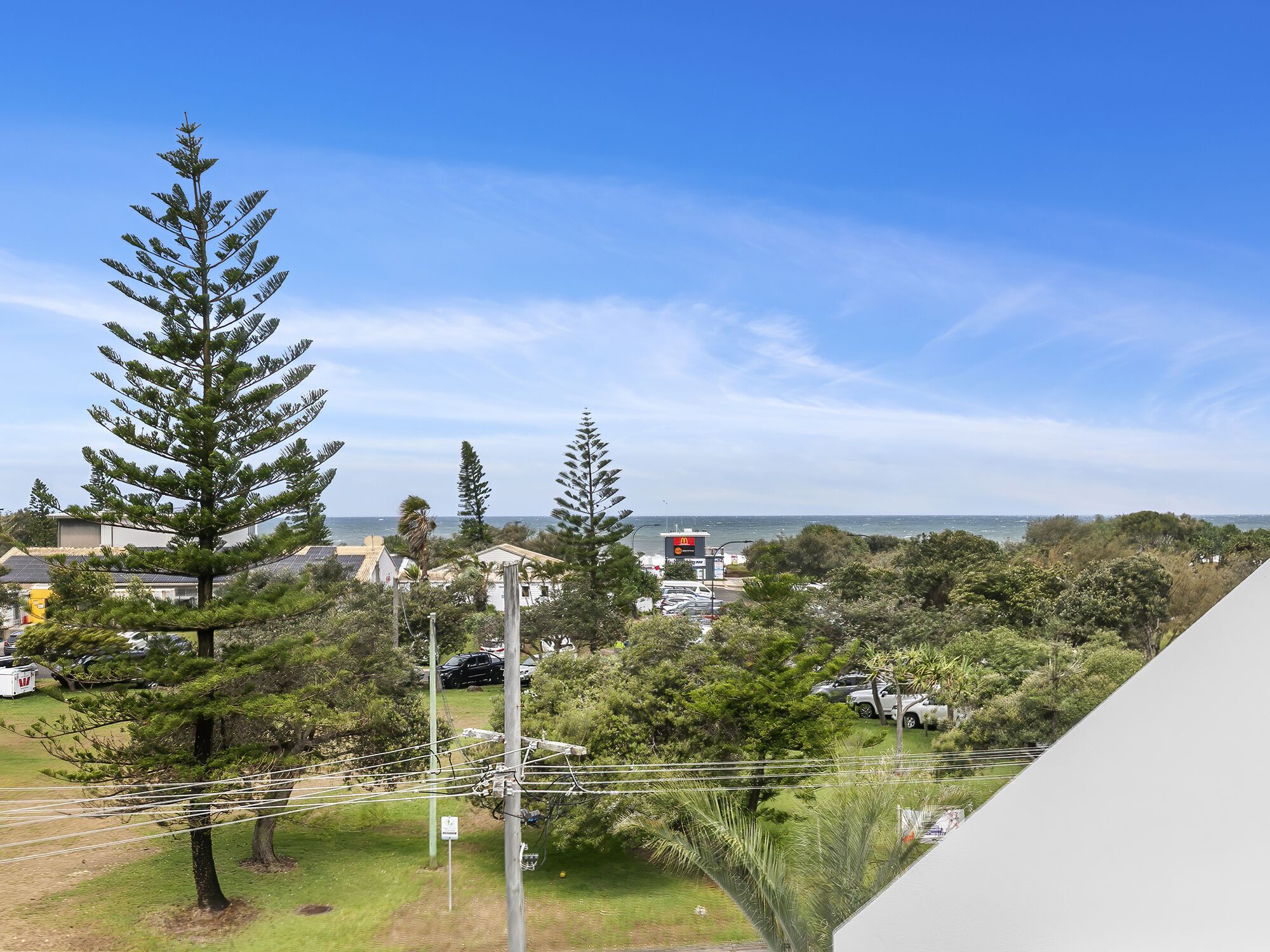 A coastal view with a McDonald's restaurant, power lines, and residential buildings.