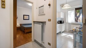 A bedroom with a bed, a radiator, and a window.