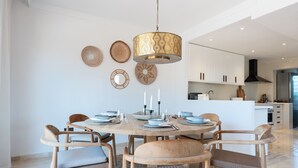 A dining area with a round table, chairs, and a hanging light fixture. - Apartment 'Casa Sunchill' with Shared Pool, Wi-Fi and Air Conditioning (Marbella)