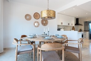 Un espace repas comprenant une table ronde, des chaises et un luminaire suspendu.