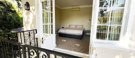A bedroom with a bed, a nightstand, and a window.