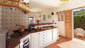 A kitchen with white cabinets, a built-in oven, a sink, and a hanging light fixture. - Villa 'Font' with Mountain View, Wi-Fi and Air Conditioning (Mancor de la Vall)