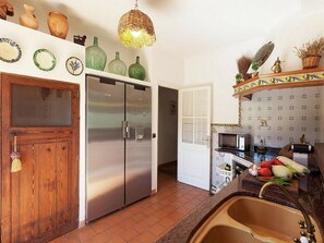 Une cuisine équipée d’un réfrigérateur, d’un évier et de divers éléments décoratifs fixés au mur.