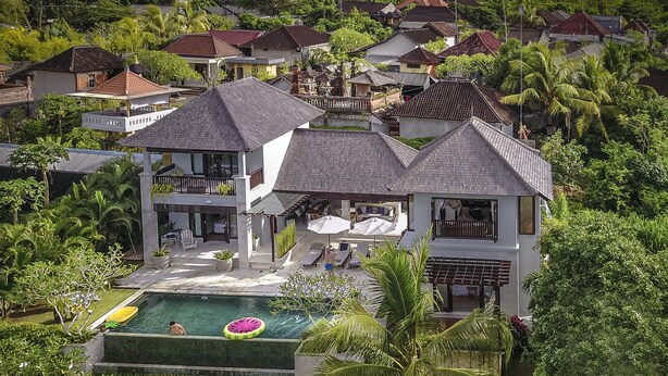 A large house with a swimming pool, surrounded by lush greenery and palm trees. - Lumi Villa Uluwatu (Pecatu)