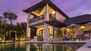 A two-story building with a balcony, a pool, and outdoor seating. - Lumi Villa Uluwatu (Pecatu)